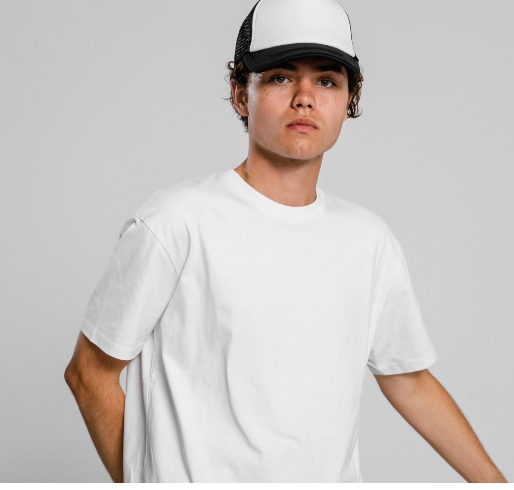 Model wearing a white tee and two-tone cap